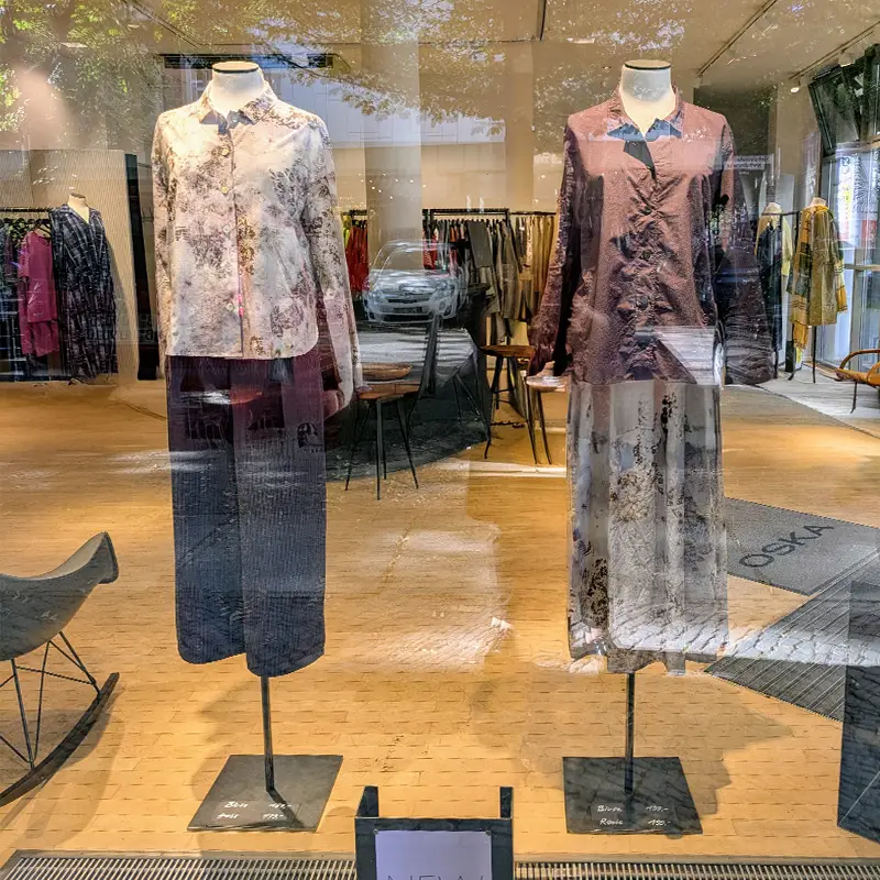 Two mannequins displaying stylish clothing in a store.